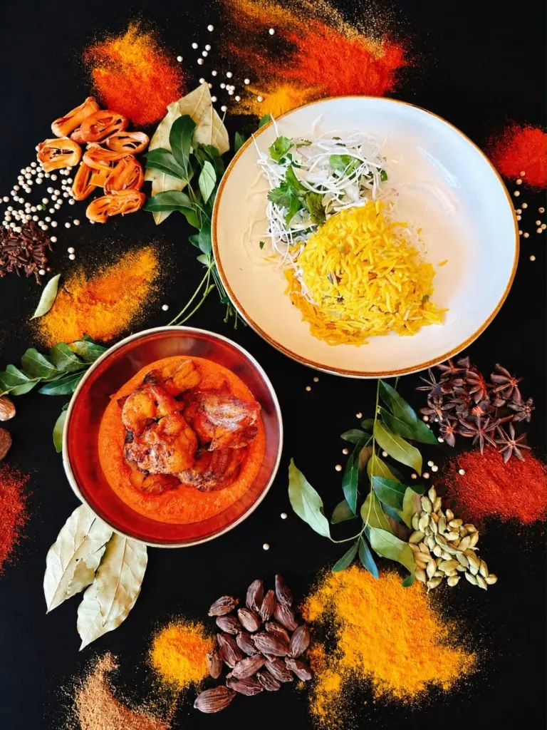 Chicken tikka sur sa sauce orangée, servi avec du riz